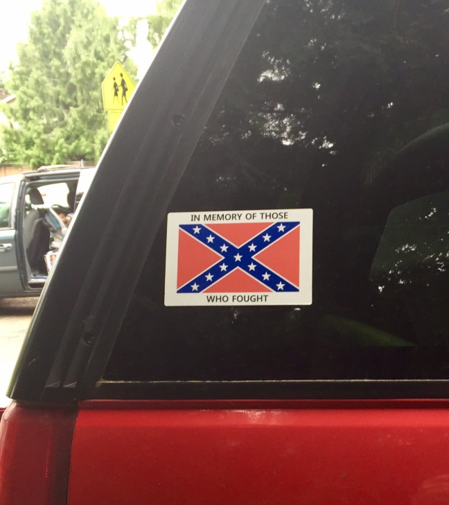 A vehicle near a school displays a Battle Flag decal saying “In memory of those who fought.”
